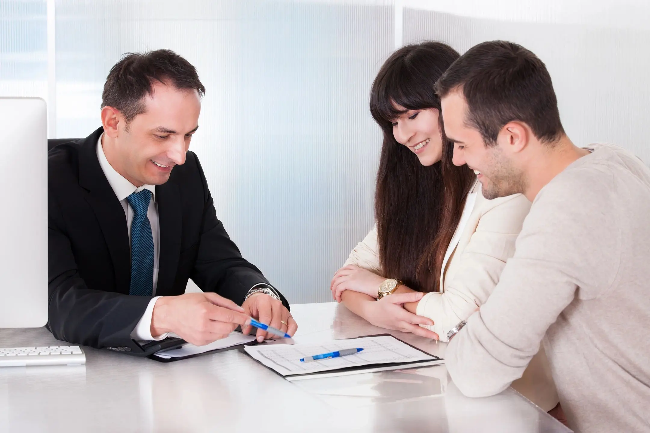 Financial advisor reviewing documents with young couple Financial advisor reviewing documents with young couple